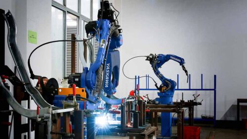 Two robotic welding arms in action