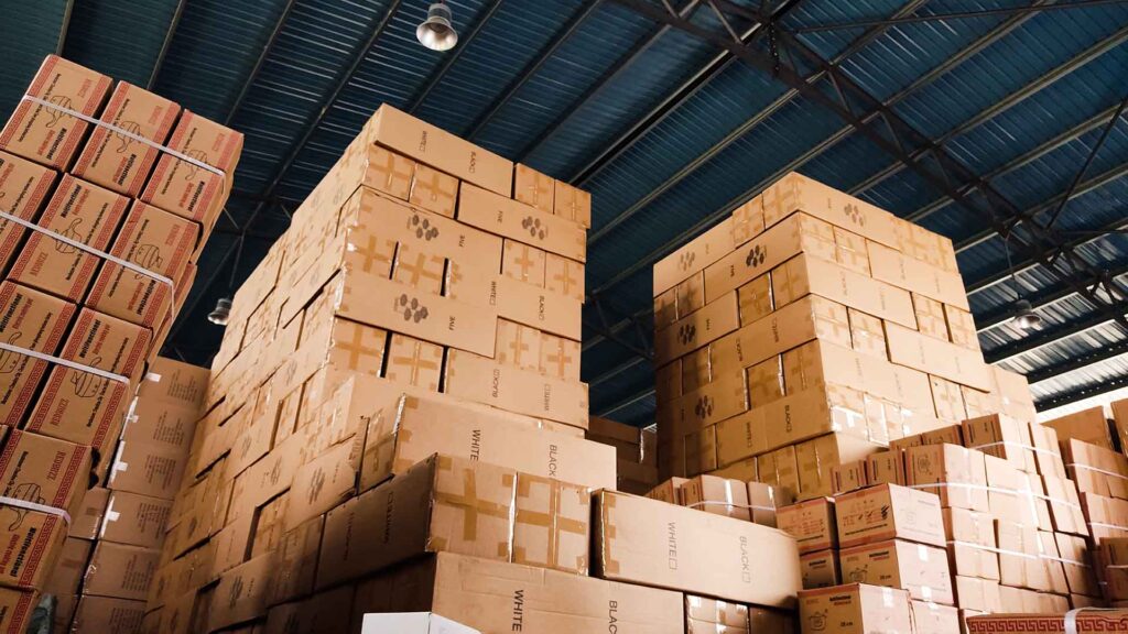 A warehouse with very tall stacks of large cardboard boxes