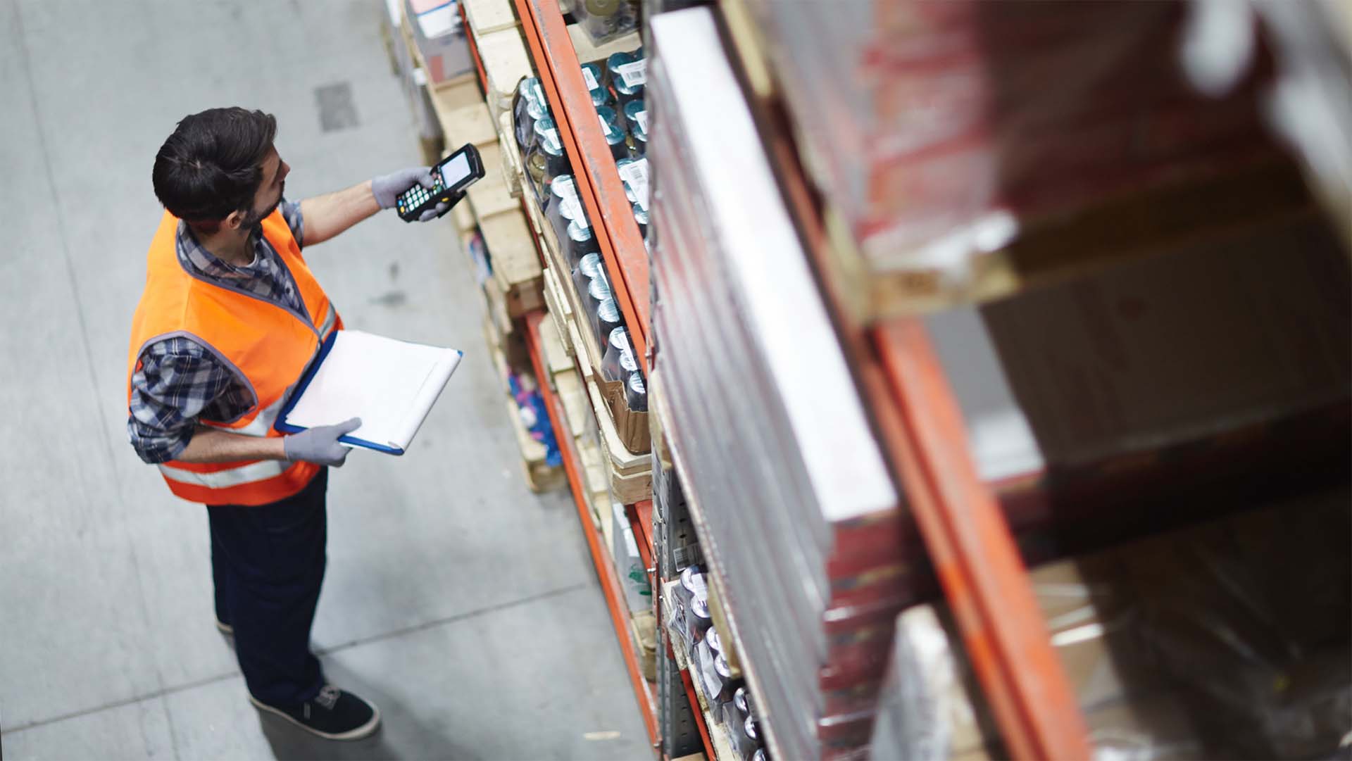 A public warehouse worker using technology to count materials and track digital inventory.