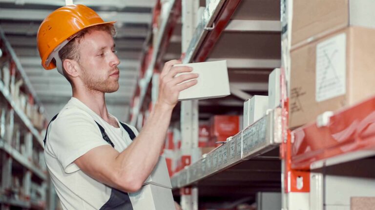 A warehouse worker zone picking a box