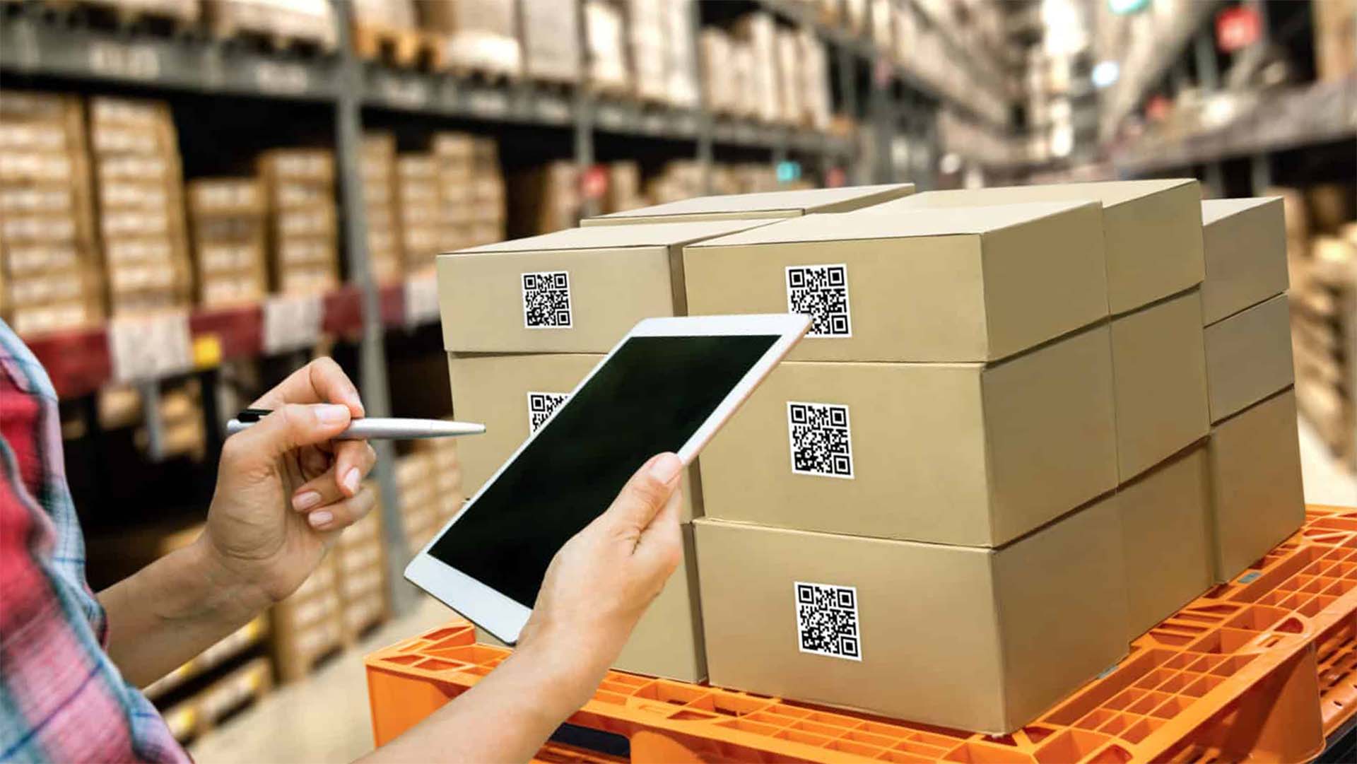 A warehouse worker using digital barcodes and mobile order tracking technology to process batch picks of orders.