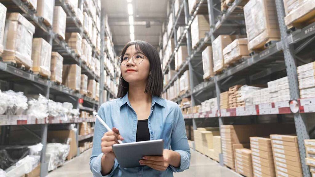 An inventory manager checking stock quantities with a tablet