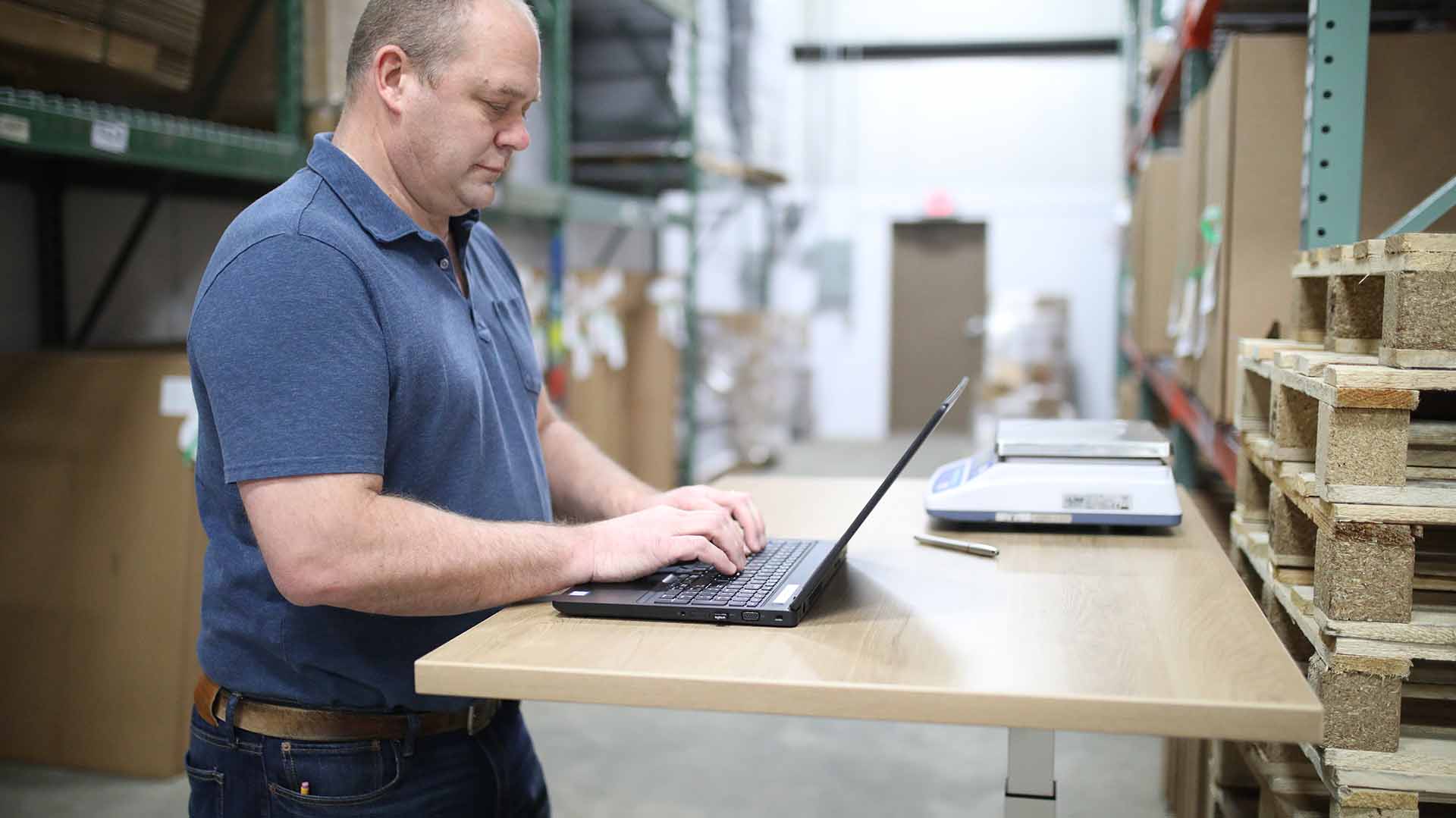 A warehouse worker using a laptop to view order fulfillment information