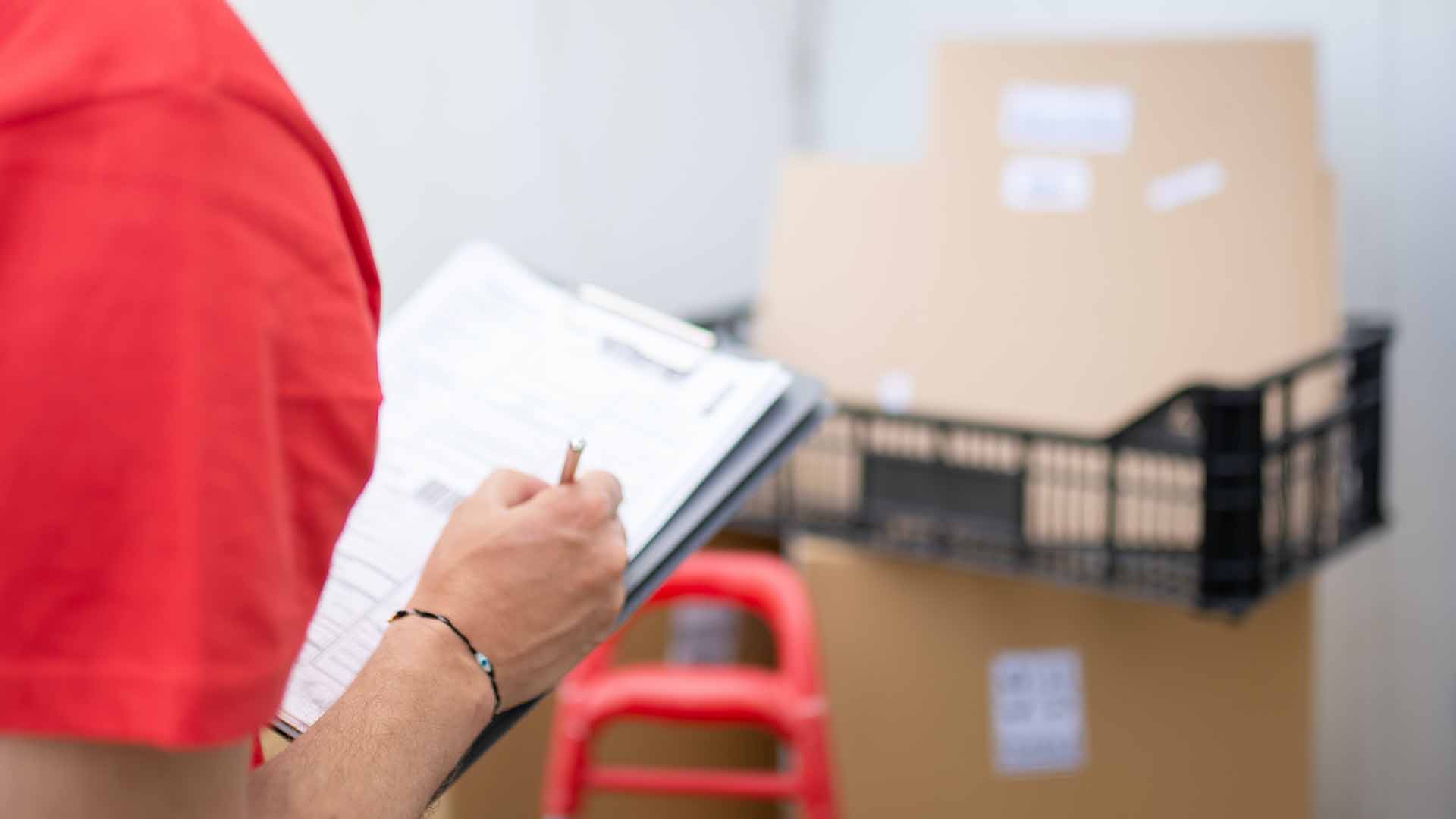 A warehouse worker checks a printed pick list