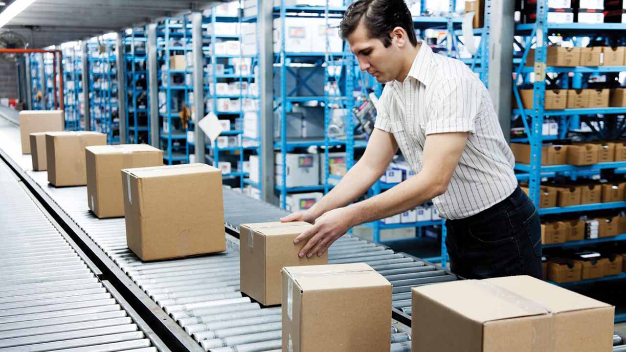 warehouse worker picking cases to a conveyor