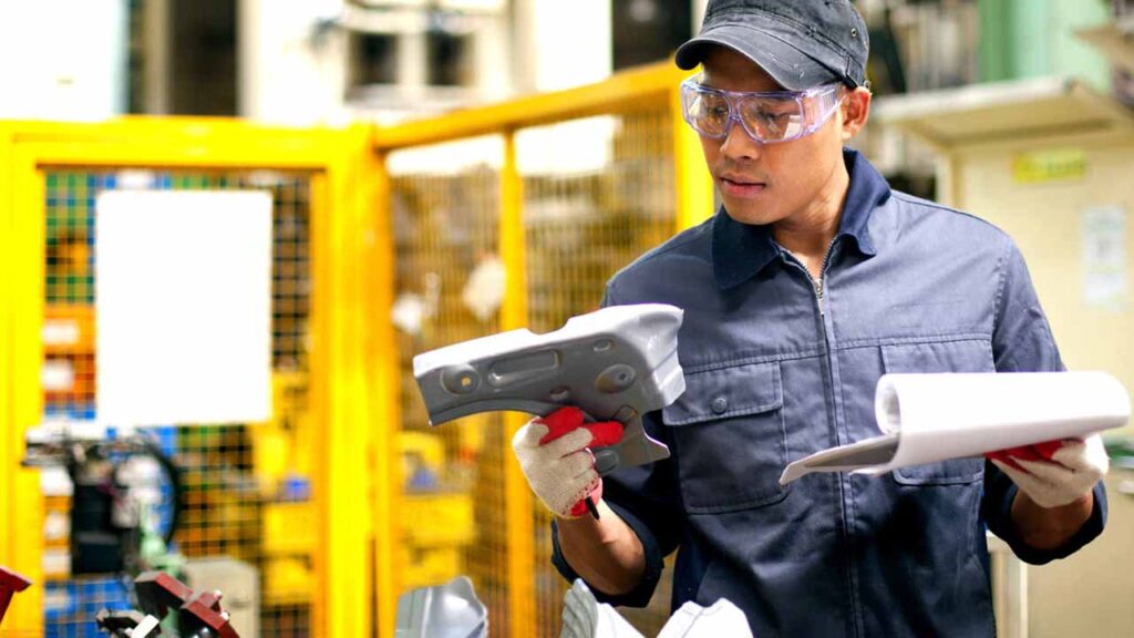 A worker inspecting the quality of a manufacturing product