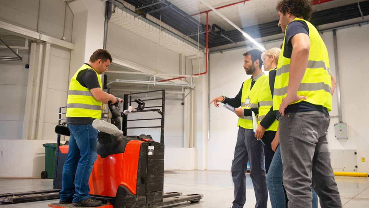 warehouse staff being trained on proper use of workspace equipment and equipment storage