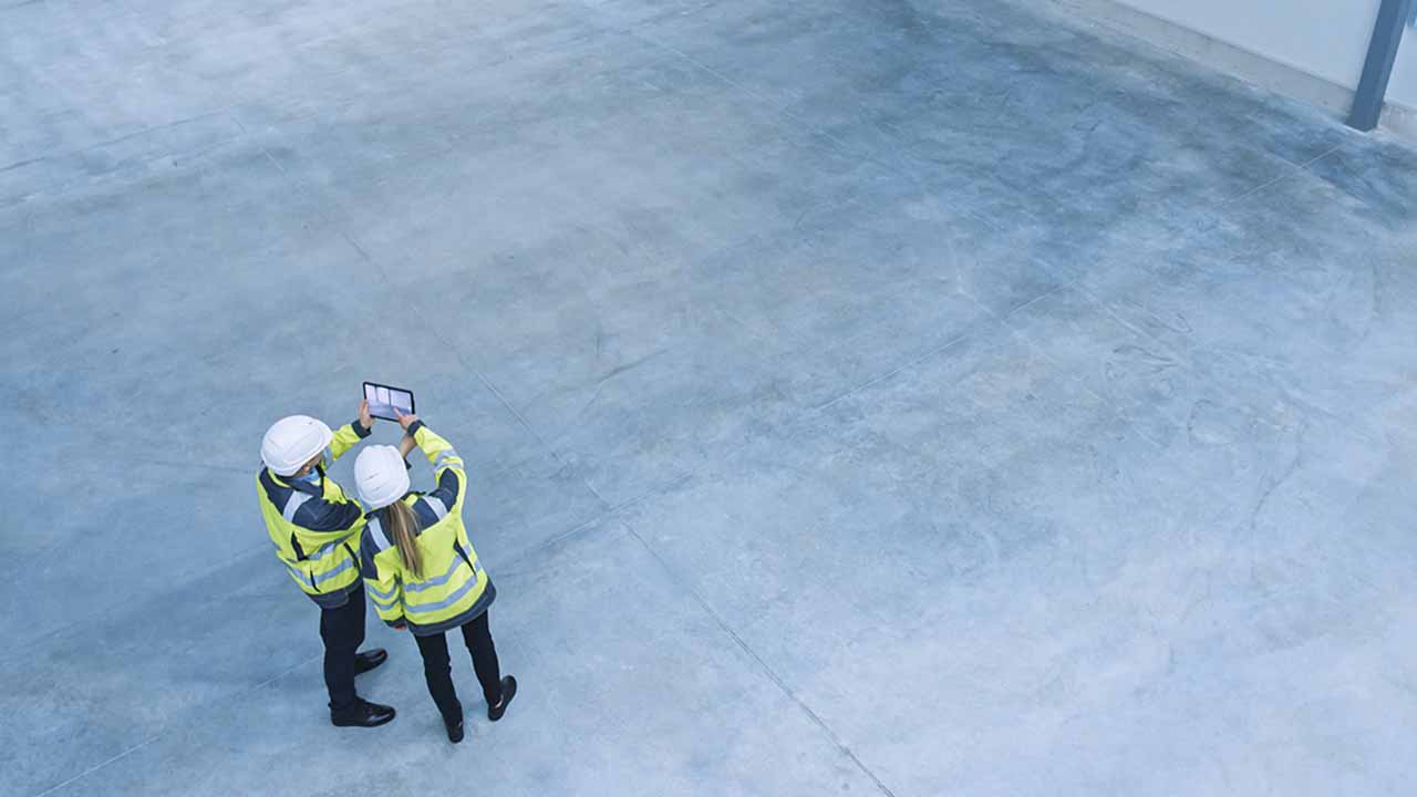 Staff deciding on efficient warehouse layout for equipment such as packing tables, warehouse aisles, and receiving and shipping areas