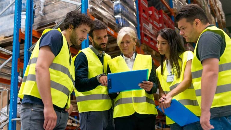 a group of warehouse workers reviewing warehouse kpis