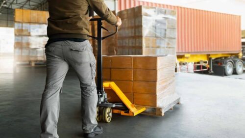 Container being unloaded from a truck at a warehouse