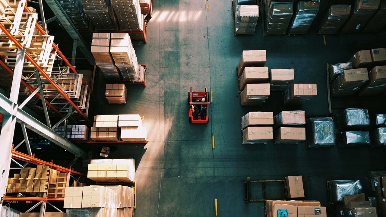 drone view of a forklift in a warehouse full of inventory