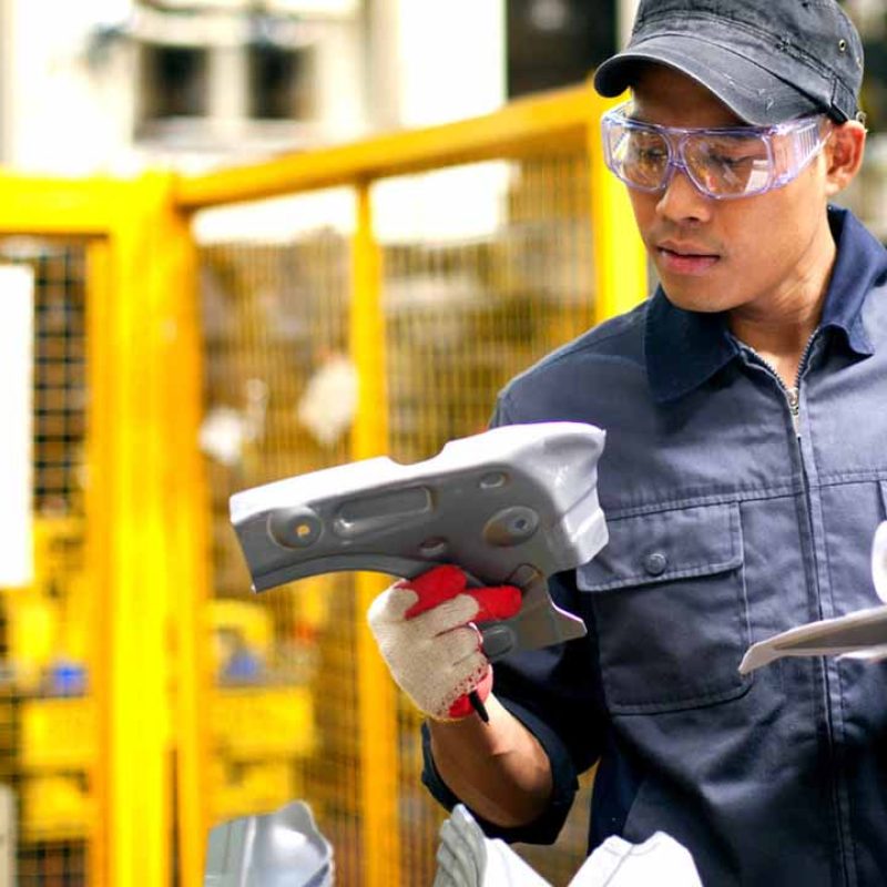 A worker inspecting the quality of a manufacturing product